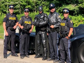 Crimefighters at the side of the highway following a Batmobile breakdown. From left are constables Ryan Rennick, Rob Sinclair, Richard Hamson and Christopher Triemstra.