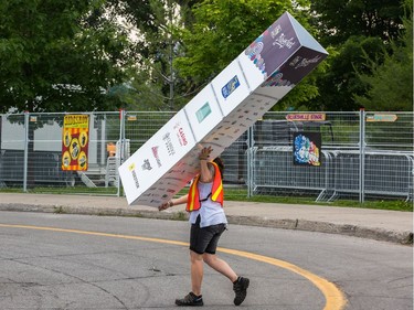 A worker carries a banner on Wednesday, July 3, 2019 as the 25th anniversary edition of Bluesfest gets ready to open on Thursday evening.  Photo by Wayne Cuddington / Postmedia
