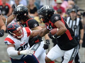Ottawa Redblacks running back Mossis Madu (right) avoids Montreal Alouettes defensive tackle Woody Baron during first half CFL action in Ottawa on Saturday.