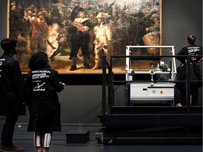 Restorers prepare Rembrandt's famous painting the 'Night Watch', protected by a glass barrier and video surveillance, as it undergoes public restoration after a first phase of study, in Rijksmuseum in Amsterdam, Netherlands July 8, 2019.