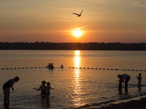 The setting sun cast a glow across Westboro Beach on the Ottawa River as a number of bathers take advantage of the cool river to escape today's heat.