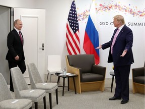 U.S. President Donald Trump, right, gestures as Russian President Vladimir Putin arrives for the talks during a bilateral meeting on the sidelines of the G-20 summit in Osaka, Japan, Friday, June 28, 2019.