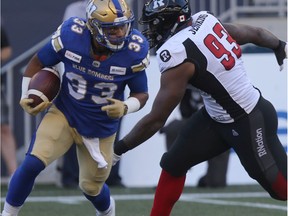 CFL Winnipeg Blue Bombers Andrew Harris (33) works past Ottawa Redblacks  Shaneil Jenkins (93) in game action, in Winnipeg. Friday, July 19/2019 Winnipeg Sun/Chris Procaylo/stf