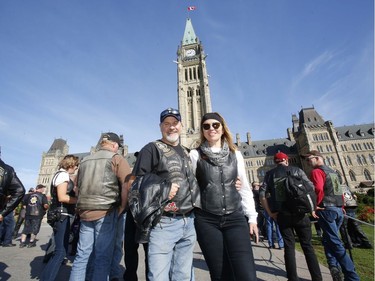 Sylvain Fregeau, left, and Martine Vezina from Montmagny Quebec pose for a photo while visiting Parliament Hill as part of "The Rolling Barrage" charity motorcycle ride on Sunday, August 11, 2019.