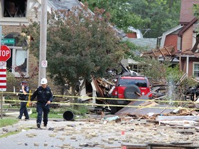 Emergency crews remained on the scene Thursday, Aug. 15, 2019, at Woodman Avenue, where a vehicle crashed into a home, causing an explosion that injured seven and damaged at least 10 homes.