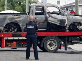 Police investigate a car fire in Buckingham, Quebec on Saturday.