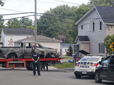 Police investigate a car fire in Buckingham, Quebec on Saturday.
