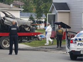 Police investigate a suspicious car fire and building in Buckingham, Quebec on August 31, 2019 .