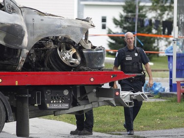 Police investigate a car fire in Buckingham, Quebec on Saturday.