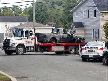 Police investigate a car fire in Buckingham, Quebec on Saturday.