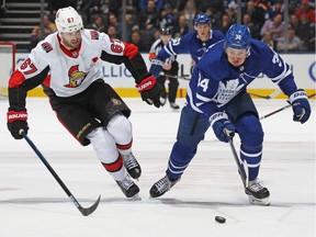 While with the Ottawa Senators in February 2019, Ben Harpur skates after the puck alongside the Toronto Maple Leafs' Auston Matthews.