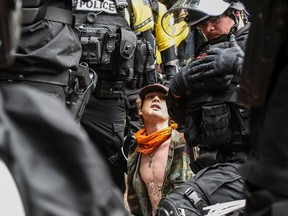 PORTLAND, OR - AUGUST 17: A is surrounded by police after being detained during an alt-right rally on August 17, 2019 in Portland, Oregon. Anti-fascism demonstrators gathered to counter-protest a rally held by far-right, extremist groups.