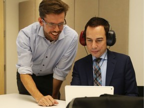 Dr. Matthew Bromwich (L) gives Alex Munter of CHEO a demonstration of the Shoebox audiometry device, August 20, 2019.