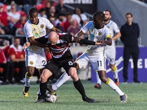 Jeremy Gagnon-LaPare of the Fury gets manhandled by Riverhounds’ Mouhamed Dabo (left) and Kenardo Forbes last night at TD Place. Pittsburgh won 4-0, handing the Fury its worst home loss in franchise history.