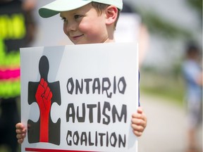 Four-year-old Owen Gibbs holds a sign during the autism rally on July 6.