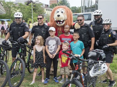 Kids pose with Ottawa police officers and Spartacat as the Ottawa Senators Foundation held a picnic at Jules Morin Park.