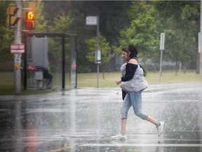 A woman runs across Meadowlands Drive as the rain started to come down.