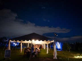 150 guests gathered at a communal table under the tent for a beautiful dinner.