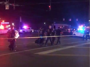 This videograb taken from the Twitter account of Derek Myers on August 4, 2019 shows police officers walking behind police cordon following a mass shooting in the popular bar and nightlife Oregon district in Dayton, Ohio. - Nine people were killed in a mass shooting early on August 4 in Dayton, Ohio, police said, adding that the assailant was shot dead by responding officers.
