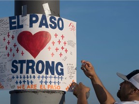 An 'El Paso Strong' sign appears at the makeshift memorial for victims of the shooting that left a total of 22 people dead at the Cielo Vista Mall WalMart (background) in El Paso, Texas, on August 6, 2019.
