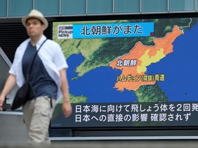 A pedestrian walks past a giant screen in Tokyo reporting about North Korea's missile launch earlier in the day, on August 10, 2019. - North Korea conducted the latest in a series of missile launches Saturday to protest US-South Korean war games, just hours after US President Donald Trump expressed his own frustration with the exercises.