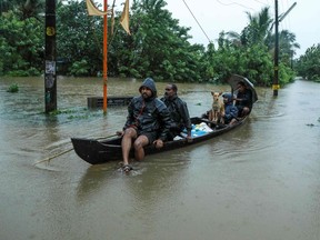TOPSHOT - Residents are being evacuated from their home to a safer place following floods warnings, on a wooden boat in Kochi in the Indian state of Kerala on August 10, 2019. - Floods have killed at least 100 people and displaced hundreds of thousands across much of India with the southern state of Kerala worst hit, authorities said on August 10.