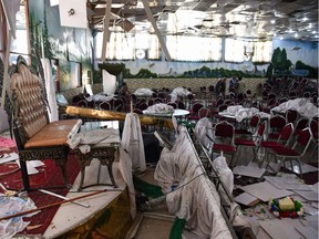 TOPSHOT - Afghan men investigate in a wedding hall after a deadly bomb blast in Kabul on August 18, 2019. - More than 60 people were killed and scores wounded in an explosion targeting a wedding in the Afghan capital, authorities said on August 18, the deadliest attack in Kabul in recent months.