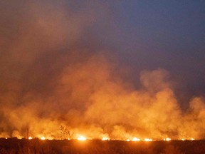 A fire burns out of control after spreading onto a farm along a highway in the Amazon basin in Brazil, on August 23, 2019.