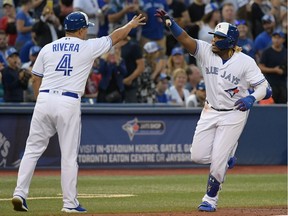Toronto Blue Jays third baseman Vladimir Guerrero Jr. celebrates with third base coach Luis Rivera after hitting a two-run home run against Seattle Mariners in the third inning at Rogers Centre.