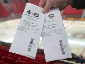 Quebec Superior Court has awarded nearly $45,000 to a man whose former brother-in-law deprived him of their Montreal Canadiens season tickets over a family dispute, ruling that he had no right to unilaterally deny access to the coveted seats. A man holds up tickets prior to an NHL hockey game between the Montreal Canadiens and the Toronto Maple Leafs at the Bell Centre in Montreal, Saturday, Feb. 9, 2013.