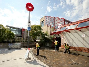 Workers clean the walkways out front as soon as the doors opened to the public at Blair LRT station around 10 am Friday.