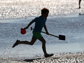 A boy runs on the beach.