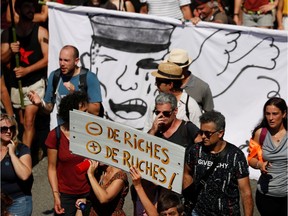 Anti-G7 protesters attend a protest march on the French-Spanish border, in Hendaye during the Biarritz G7 summit, France, August 24, 2019. The placard reads "less rich and more beehives".