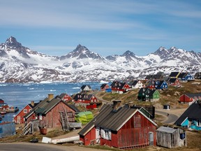 Snow covered mountains rise above the harbour and town of Tasiilaq, Greenland, June 15, 2018.