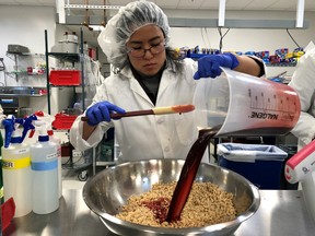 Impossible Foods research technician Alexia Yue pours a heme solution, the key ingredient, into a plant-based mixture for burgers at their facility in Redwood City, California, U.S. March 26, 2019.