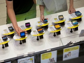 Customers browse mobile phones at the Toronto Eaton Centre in Toronto, Ontario, Canada, on Thursday, June 20, 2013.