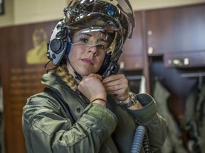Capt. Anneliese Satz puts on her flight helmet prior to a training flight aboard Marine Corps Air Station in Beaufort, South Carolina, on March 11, 2019.