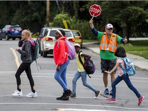 Adult crossing guard Bruce Mallett helps students at the intersection of Haig Drive and Russell Road.