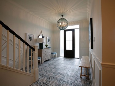 The beach house vibe is apparent right from the front door, with turquoise patterned tile donated by Euro Tile & Stone, and a fun Currey & Company beaded light fixture. 'I'm all about statement lights,' says Collins.