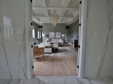 The master suite stretches across the back of the home with the bedroom flanked by the ensuite on one side and a walk-through closet on the other. Coffered ceilings and porcelain-clad ensuite walls add to the elegance.