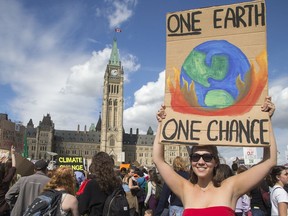 Sydney Hutchison with her sign on Parliament Hill as the Global Climate Protest took to the streets of Ottawa on Friday afternoon.