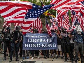 Protesters wave U.S flags outside the U.S consulate after delivering a petition on Sunday in Hong Kong, China. Pro-democracy protesters have continued demonstrations across Hong Kong.