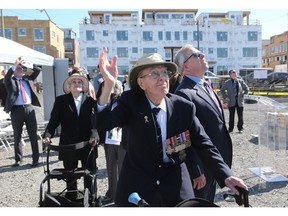 Second World War veteran Andy Carswell, 96, and his son John, watch the flypast of a Canso PBY during the cornerstone laying ceremony of the Veterans' House Canso Campus in Ottawa, Andy's wife, Dorothy, 98, is at left.