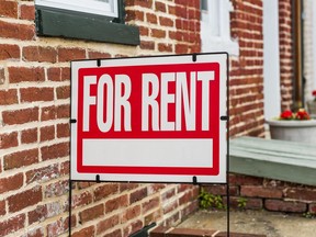 Red For Rent sign closeup against brick building