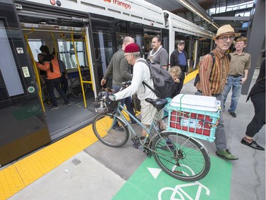 A man boards the train with his bike at the Pimisi Station as the LRT officially opens on September 14, 2019 complete with ceremonies at Tunney's Pasture.