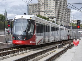 The train is seen exiting the tunnel at uOttawa with Parliament Hill looming in the background as the LRT is in operation on day 2 of the system up and running. Photo by Wayne Cuddington/ Postmedia