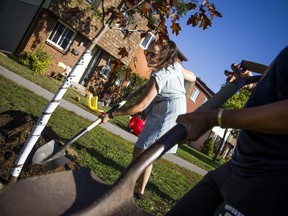 A group of residents in the Craig Henry area came together to plant a tree Saturday, Sept. 21, 2019, recognizing the first  anniversary of the tornado hitting the area. Victoria Tavares shovels some dirt onto the newly planted tree.   Ashley Fraser/Postmedia