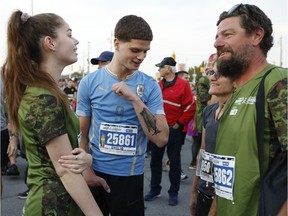Emilio Dutra-Lidington, who lost his right leg and part of his right hand in a boating accident just over a year ago, shows off his shark tattoo at the 5K start for ill and injured at the Army Run on Sunday, Sept. 22, 2019.