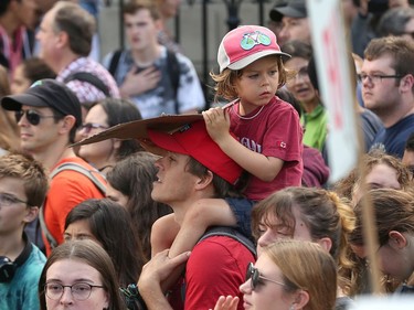 A youngster rides on his dad's shoulders as a large groups heads towards Parliament Hill as the Global Climate Protest took to the streets of Ottawa on Friday afternoon.