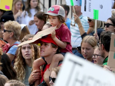 A youngster rides on his dad's shoulders as a large groups heads towards Parliament Hill as the Global Climate Protest took to the streets of Ottawa on Friday afternoon.